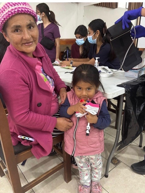 Mother and child at a community health screening in Lima, Peru